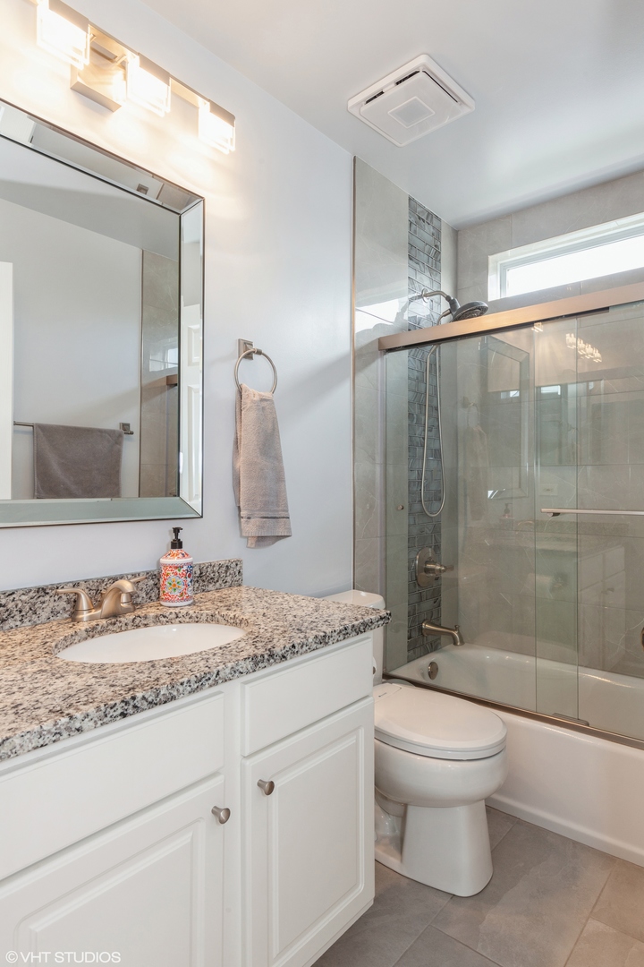 724 Wildflower Circle Naperville, IL 60540 - Photo 19 of 31 a bathroom with a granite countertop sink a toilet a mirror and shower