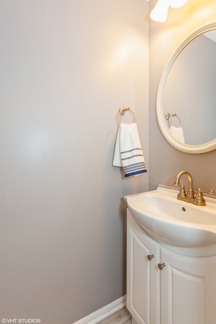 724 Wildflower Circle Naperville, IL 60540 - Photo 24 of 31 a bathroom with a sink and a mirror