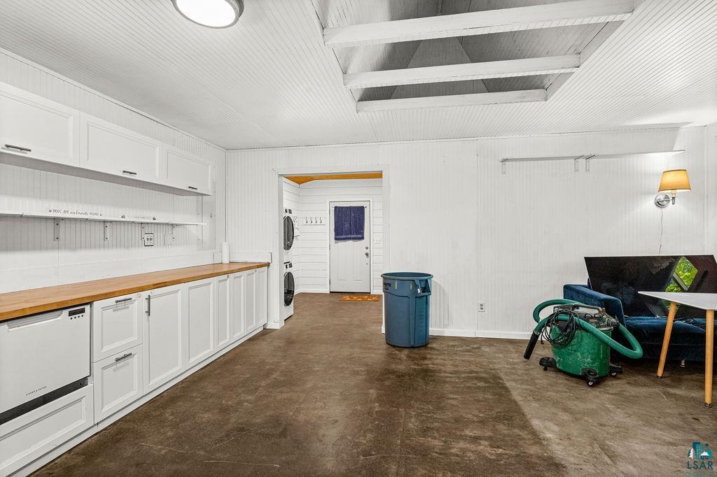 1159 Wales Road Two Harbors, MN 55616 - Photo 10 of 29 White beadboard paneling, exposed ceiling beams, wood-finish countertops, white cabinetry with silver-tone hardware, and a wall-mounted sconce