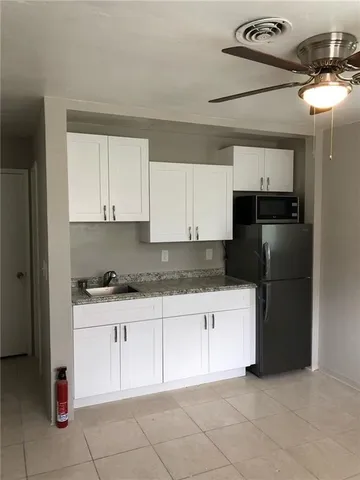 a kitchen with a sink a refrigerator and cabinets