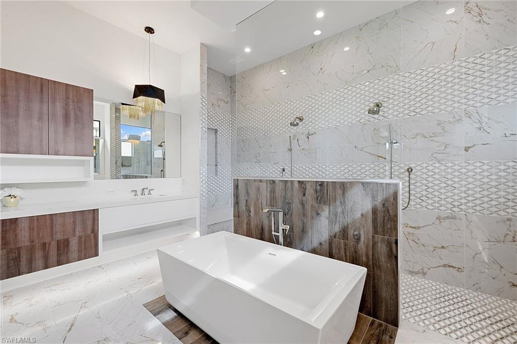 607 Myrtle Road Naples, FL 34108 - Photo 31 of 45 a large bathroom with a tub a sink and a large mirror