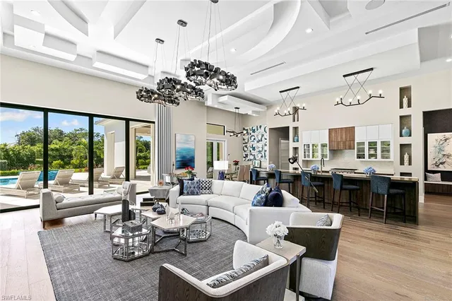 a living room with lots of furniture hardwood floor and a large window