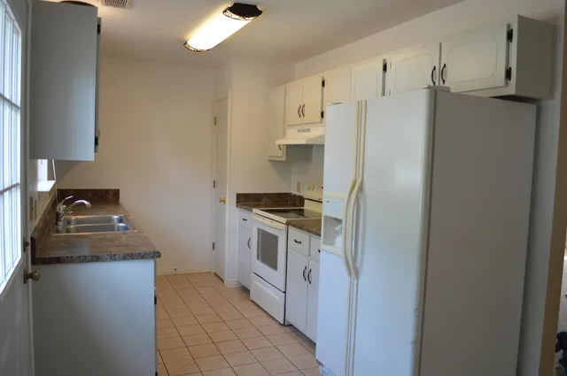 a kitchen with stainless steel appliances granite countertop a refrigerator and a stove