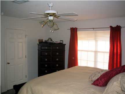 9712 Seafarer's Way Navarre, FL 32566 - Photo 7 of 8 a bedroom with a bed and a window