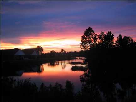 9712 Seafarer's Way Navarre, FL 32566 - Photo 8 of 8 a sunset view with a lake