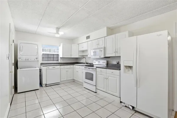 a kitchen with white cabinets and white appliances