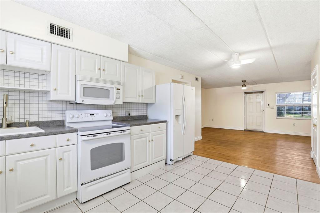 525 South Conway Road, Unit 70 Orlando, FL 32807 - Photo 19 of 28 a kitchen with white cabinets and white appliances