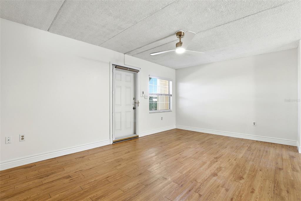 525 South Conway Road, Unit 70 Orlando, FL 32807 - Photo 21 of 28 an empty room with wooden floor ceiling fan and windows