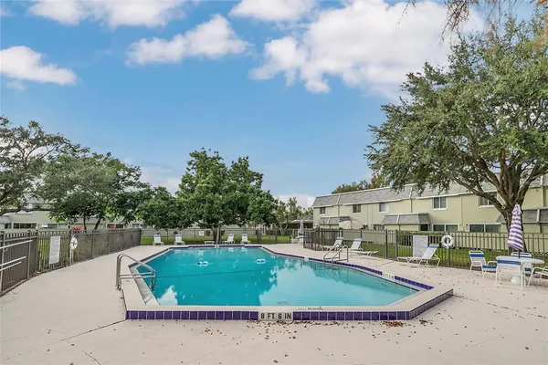a view of a swimming pool with a patio and a yard