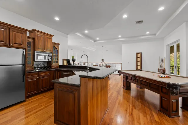 a kitchen with stainless steel appliances granite countertop a sink a stove and a refrigerator