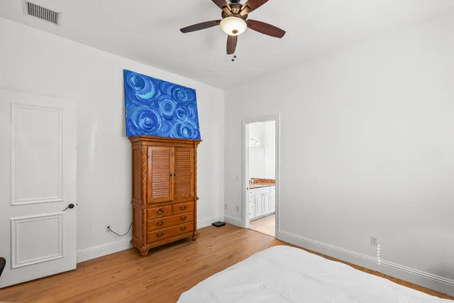 an empty room with wooden floor closet and windows
