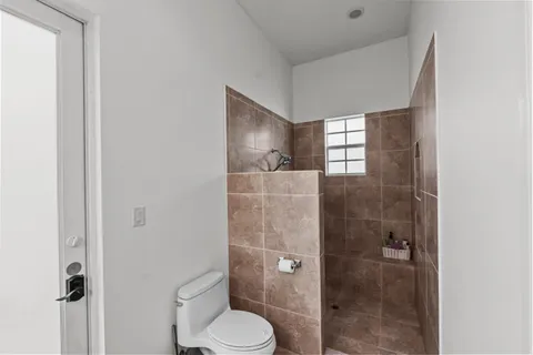 a bathroom with a toilet and a shower
