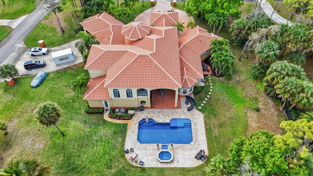 an aerial view of a house with swimming pool and garden