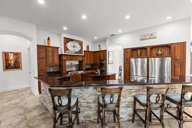 a kitchen with stainless steel appliances granite countertop a stove a sink and a refrigerator