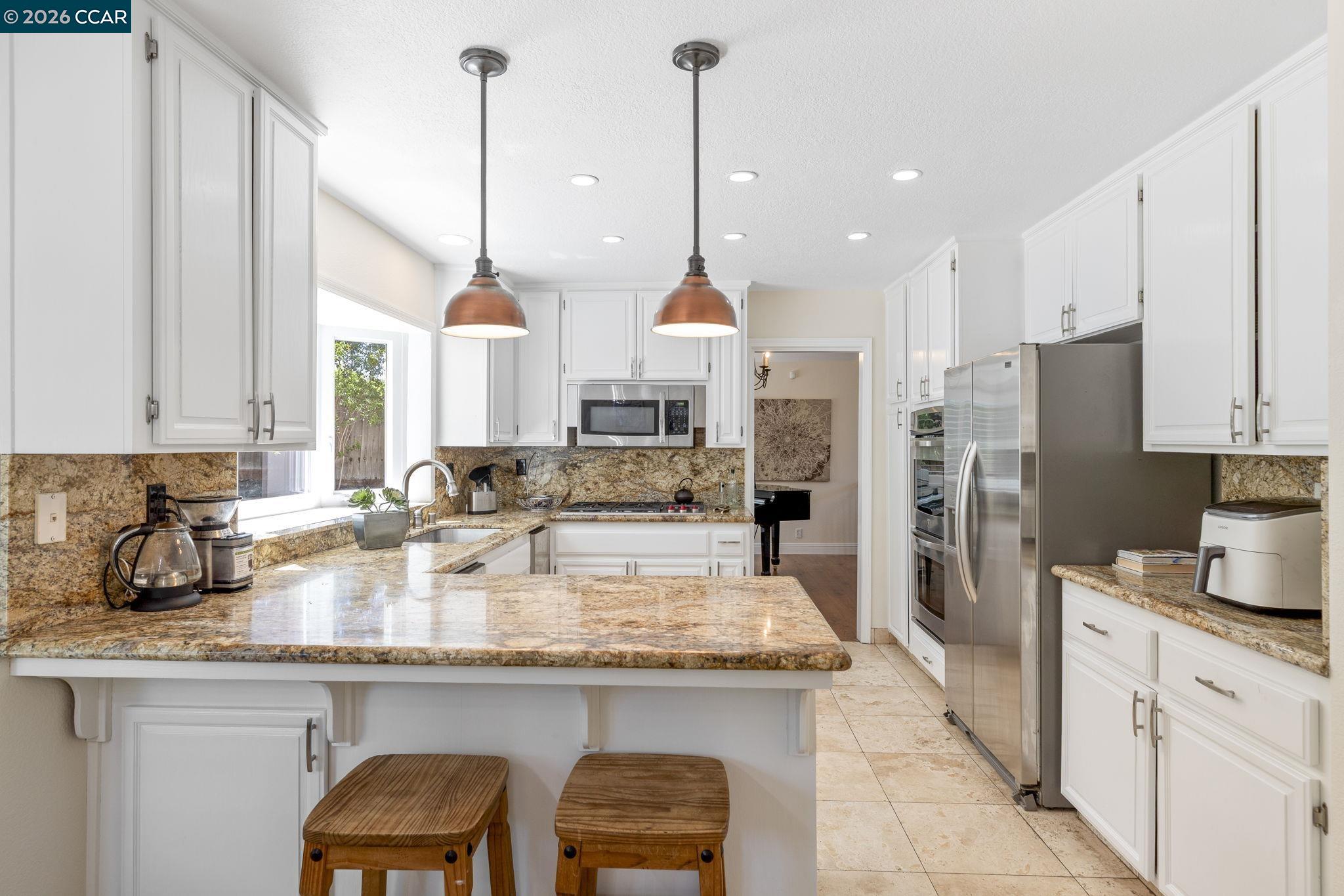 1267 Quiet Circle Concord, CA 94521 - Photo 21 of 72 a kitchen with stainless steel appliances granite countertop a sink a stove and a refrigerator
