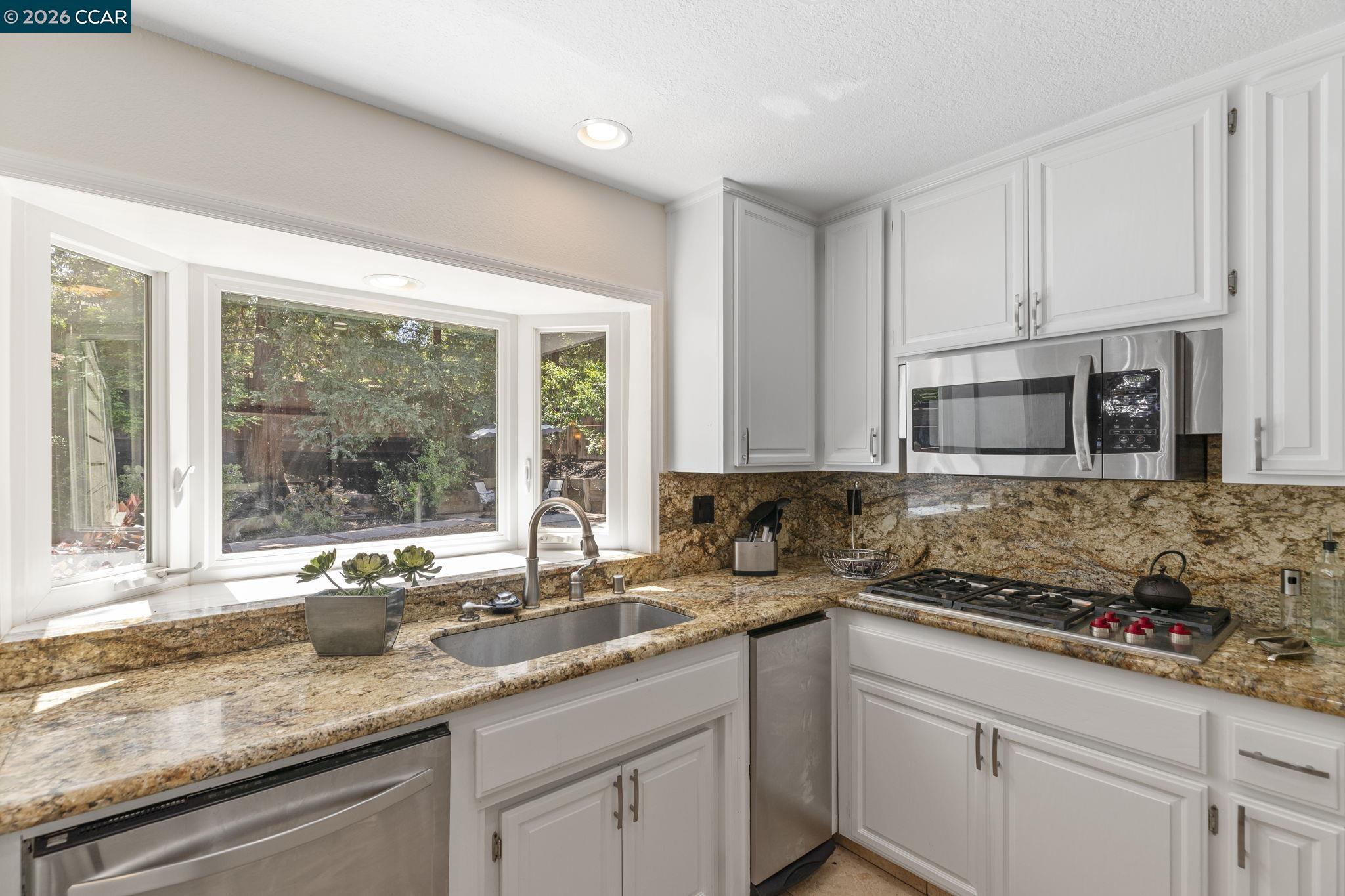1267 Quiet Circle Concord, CA 94521 - Photo 22 of 72 a kitchen with granite countertop a sink and a stove