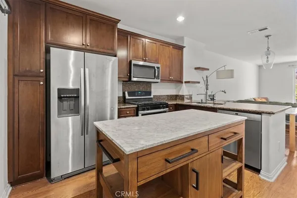 a kitchen with kitchen island a wooden floor and refrigerator