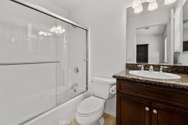 a bathroom with a granite countertop sink toilet a mirror and shower