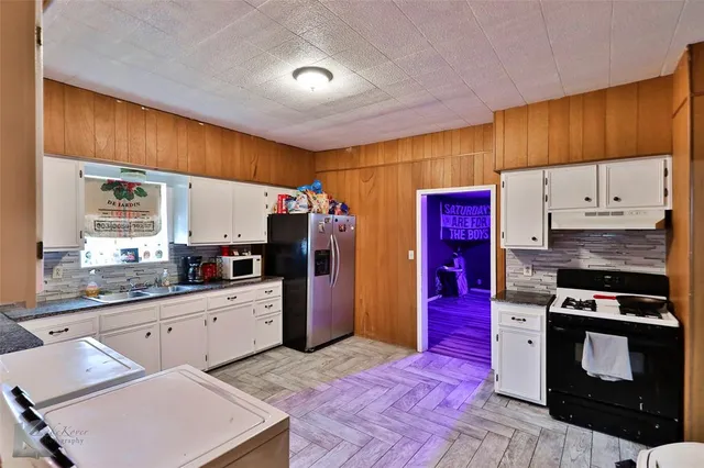 a kitchen with stainless steel appliances granite countertop a stove refrigerator sink and cabinets