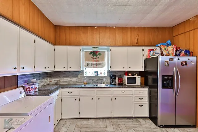 a kitchen with refrigerator and cabinets