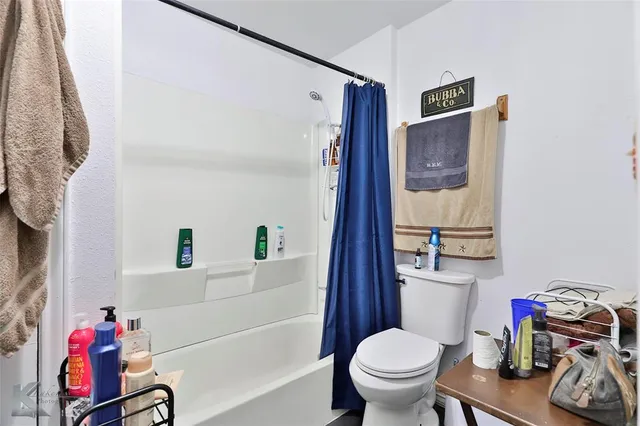 a bathroom with a toilet and a shower curtain