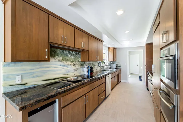 a kitchen with stainless steel appliances granite countertop a stove a sink and a refrigerator