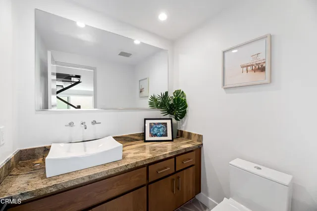 a view of a patio with couches table and chairs under an umbrella with wooden floor