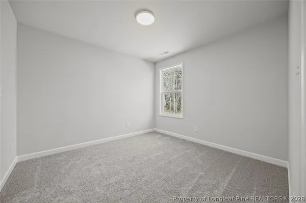 a view of room with walk in closet and wooden floor