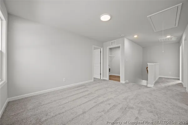 a view of an empty room and chandelier fan