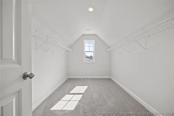 a view of an empty room with a window and fireplace