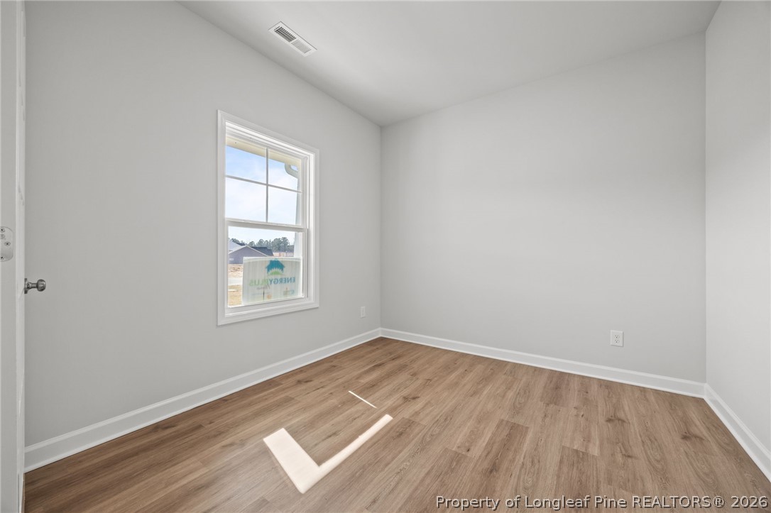 155 Michter Street Vass, NC 28394 - Photo 27 of 46 an empty room with wooden floor and windows