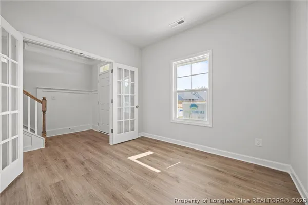 a view of a livingroom with a chandelier wooden floor and a chandelier