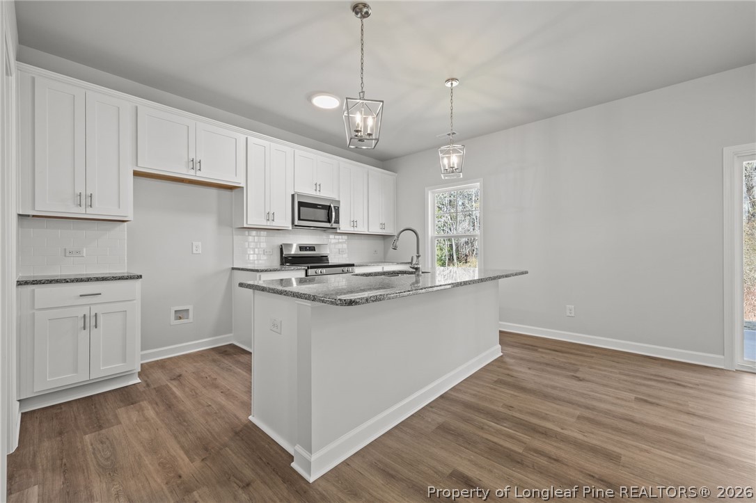 155 Michter Street Vass, NC 28394 - Photo 38 of 46 a kitchen with kitchen island white cabinets and white appliances