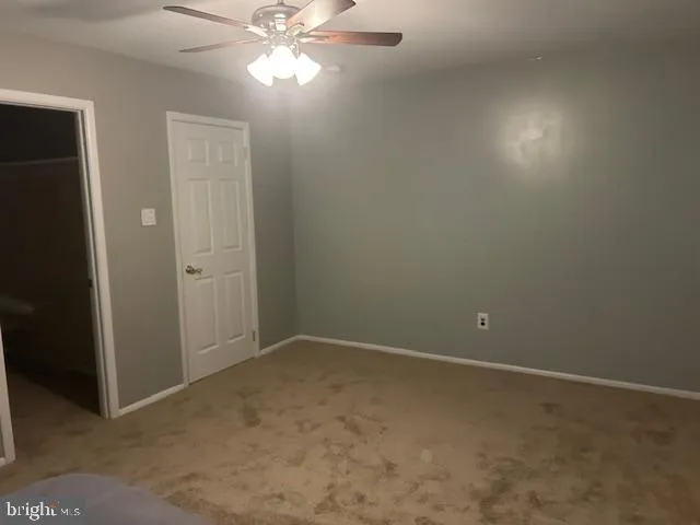 an empty room with a fan and a window