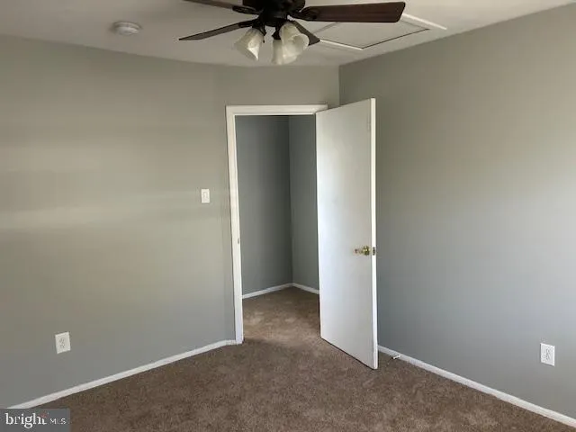 an empty room with a ceiling fan and painted walls
