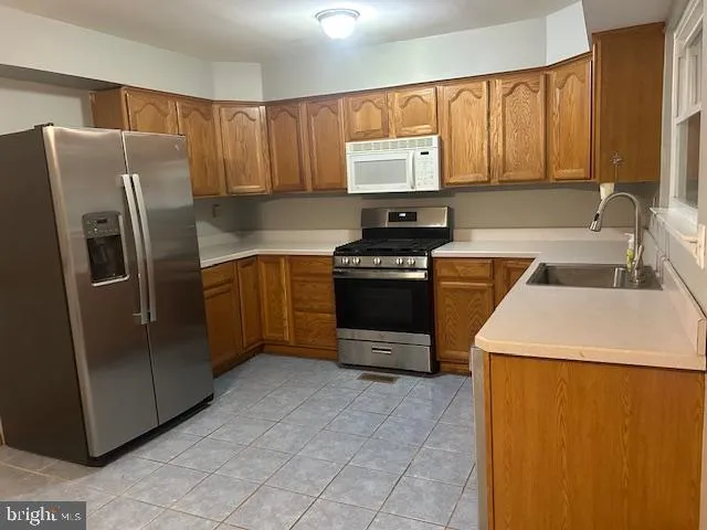 a kitchen with stainless steel appliances a refrigerator sink and cabinets