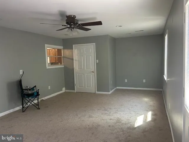 a view of an empty room and a ceiling fan