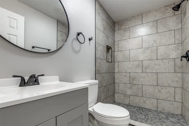 a bathroom with a sink mirror toilet and shower