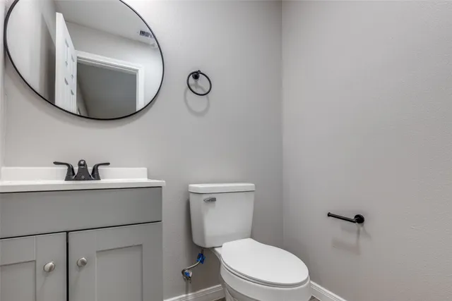 a bathroom with a toilet a sink and mirror