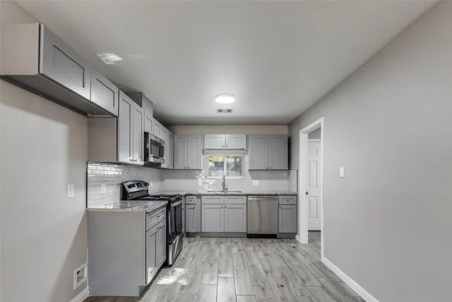 a kitchen with stainless steel appliances granite countertop a sink and cabinets