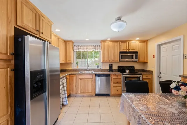a kitchen with stainless steel appliances granite countertop a refrigerator stove top oven and sink