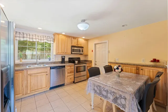 a kitchen with a stove a sink a dining table and chairs