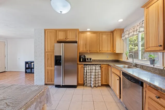 a kitchen with stainless steel appliances granite countertop a refrigerator and a sink