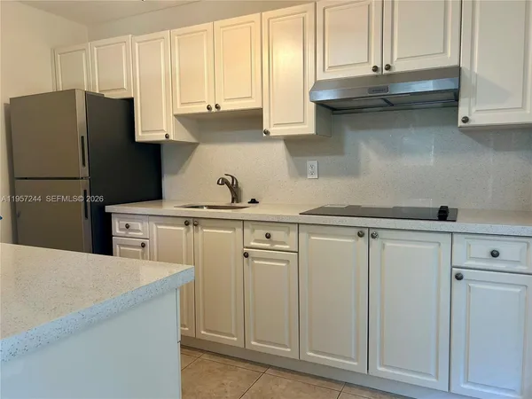 a kitchen with stainless steel appliances white cabinets and a refrigerator