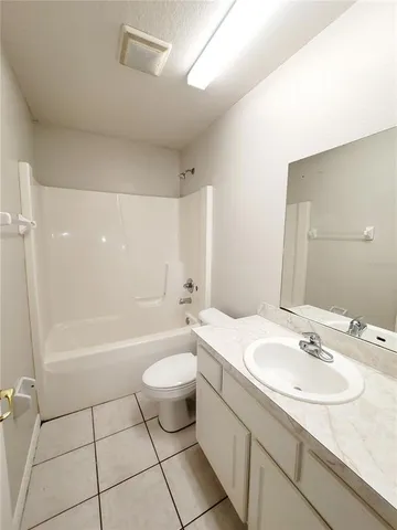 a bathroom with a sink a toilet a mirror and bathtub