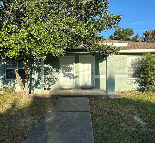 a view of a yard with plants and a fountain