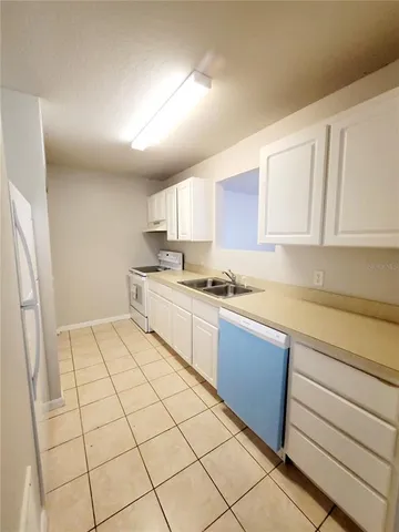 a kitchen with a sink a stove cabinets and a window