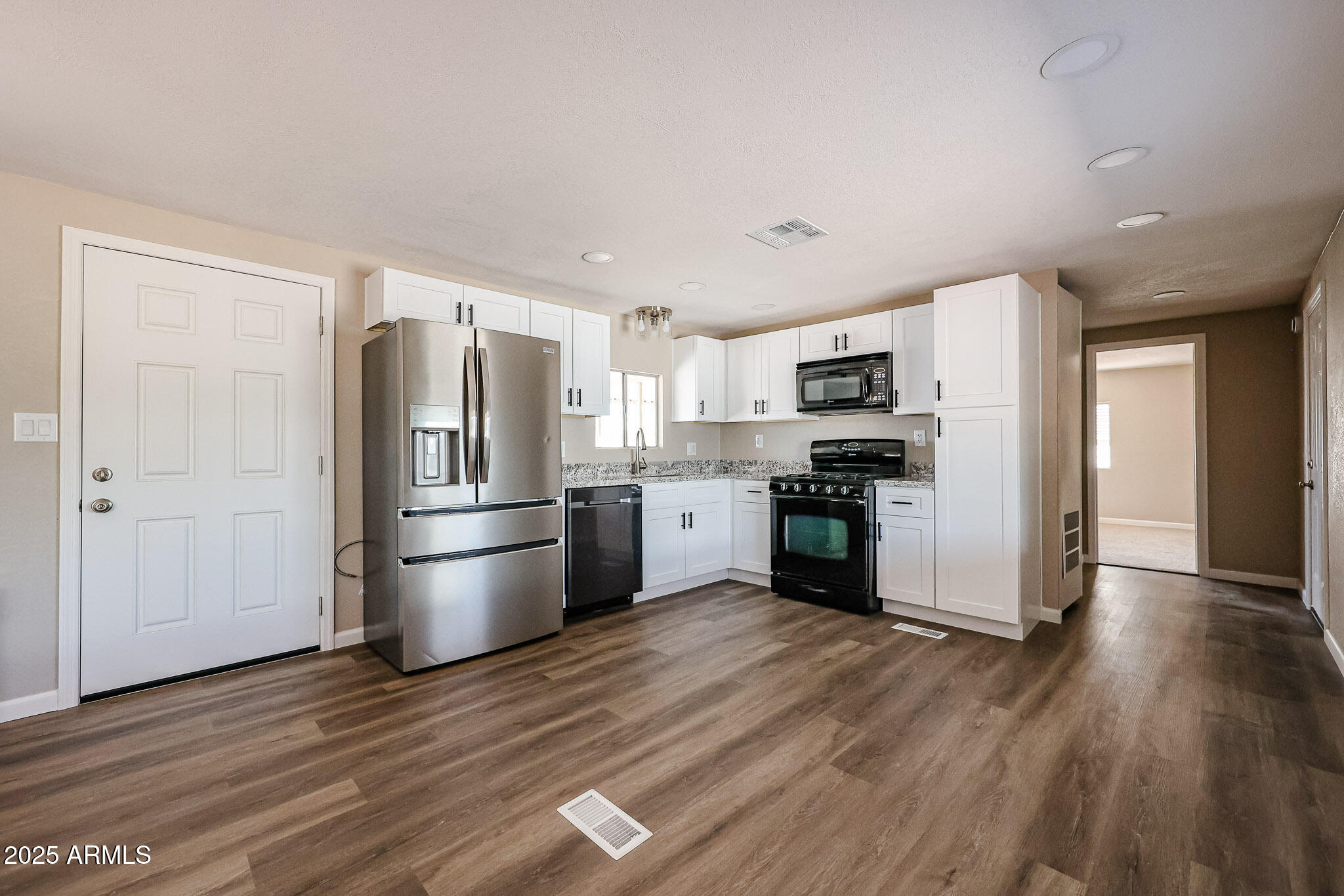 a kitchen with stainless steel appliances a refrigerator and a stove top oven