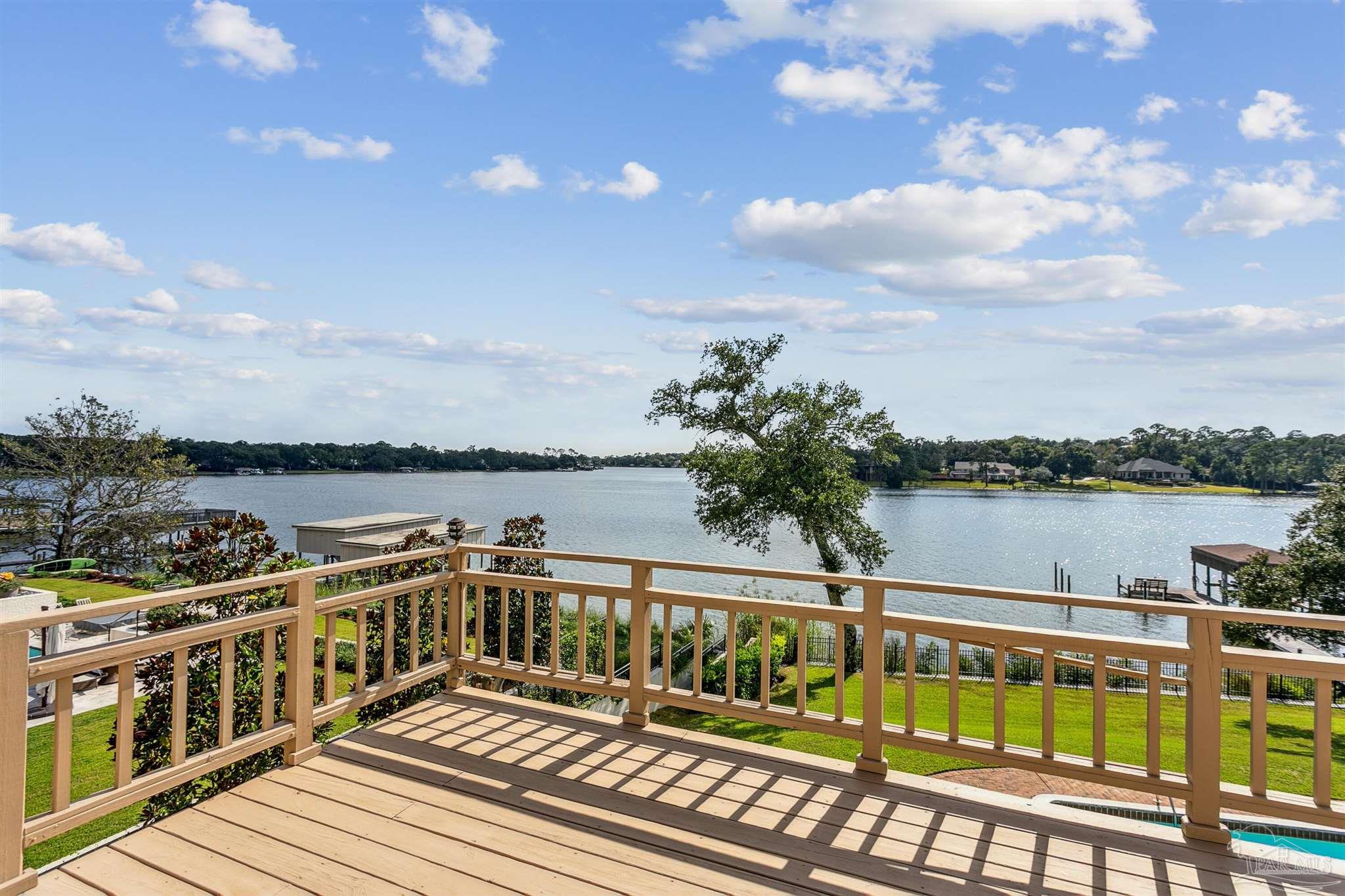 a view of a balcony with wooden floor and lake view