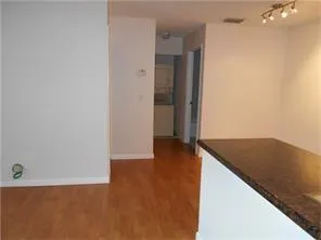 an empty room with wooden floor and cabinet